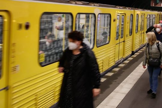 Fahrgäste gehen auf dem Bahnsteig zu einer U-Bahn (Symbolbild): Ein Mann wurde auf ein Gleisbett geschubst.