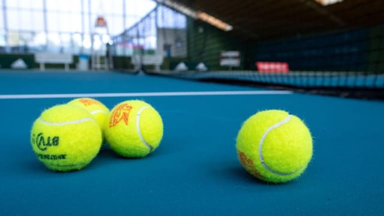Bälle liegen in einer Tennishalle in Bayern auf dem Boden.