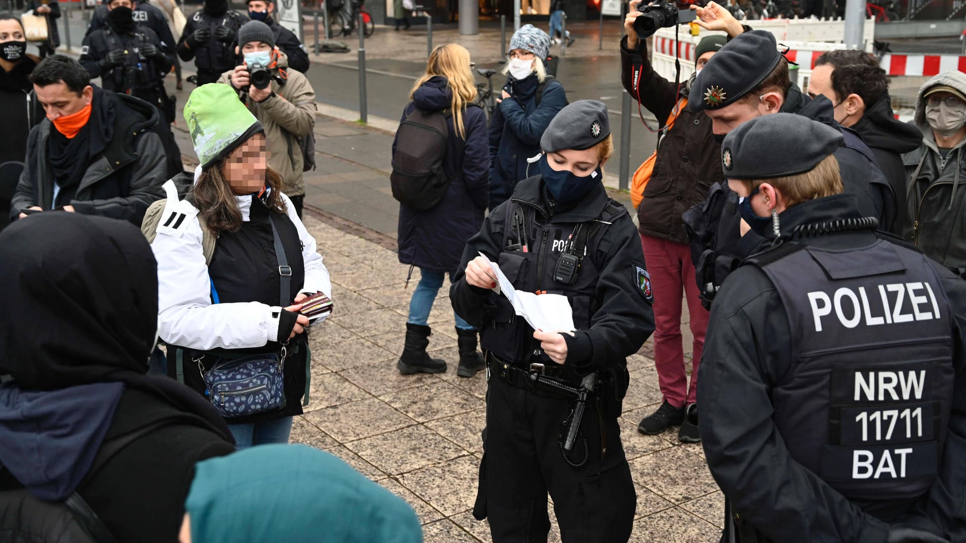 Polizisten bei der Kontrolle von Attesten zur Befreiung von der Maskenpflicht: Bei Corona-Protesten haben Polizisten eine Zahl neuer Aufgaben zu erledigen.