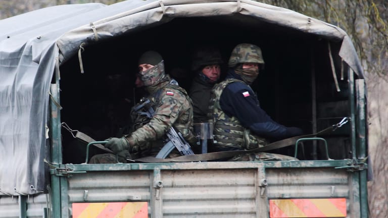 Polnische Soldaten mit Schnellfeuerwaffen auf dem Weg zum Grenzübergang Kuźnica: Keiner soll rüberkommen.