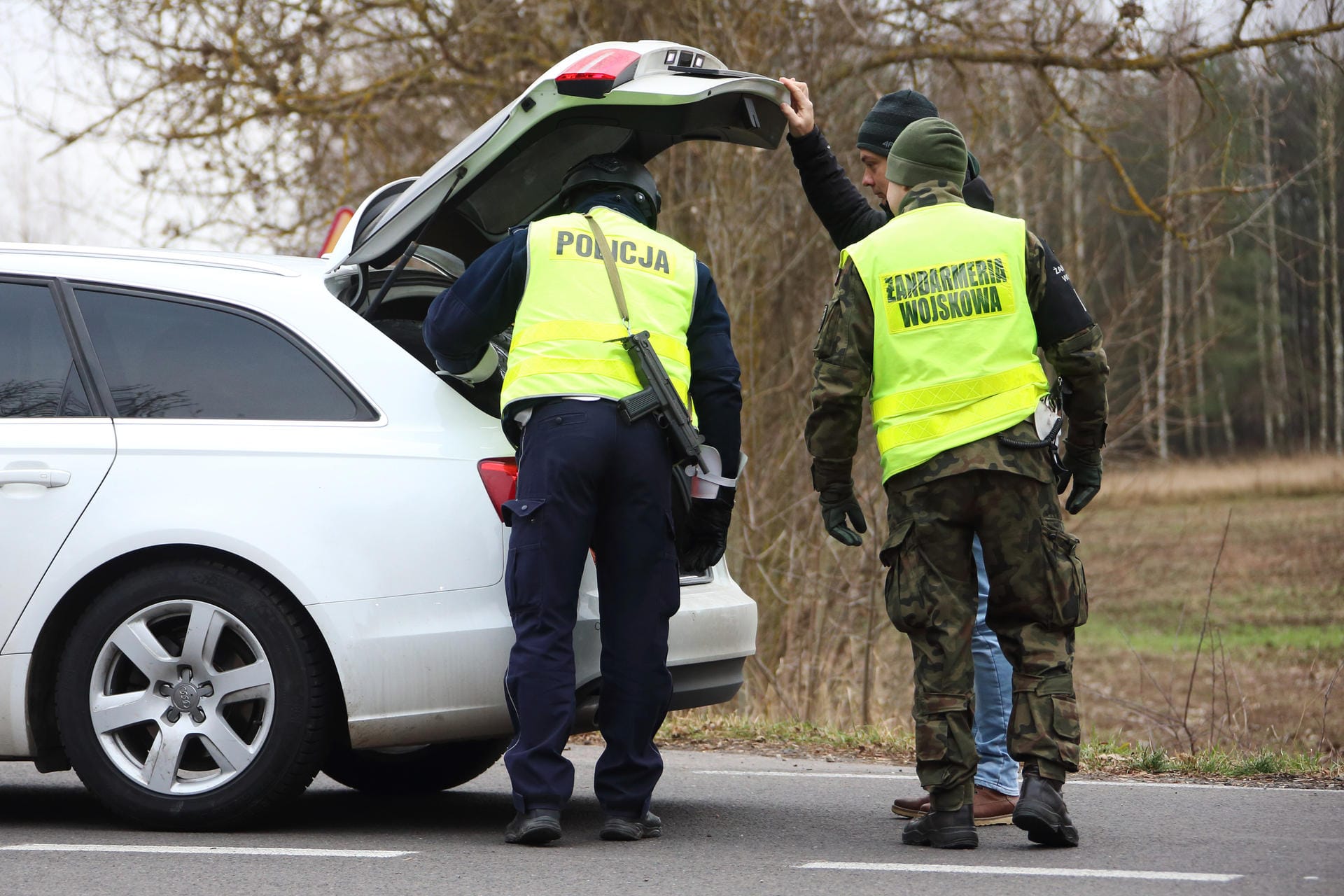 Polizisten an der polnisch-belarussischen Grenze durchsuchen jeden Kofferraum der vorbeifahrenden Zivilfahrzeuge.