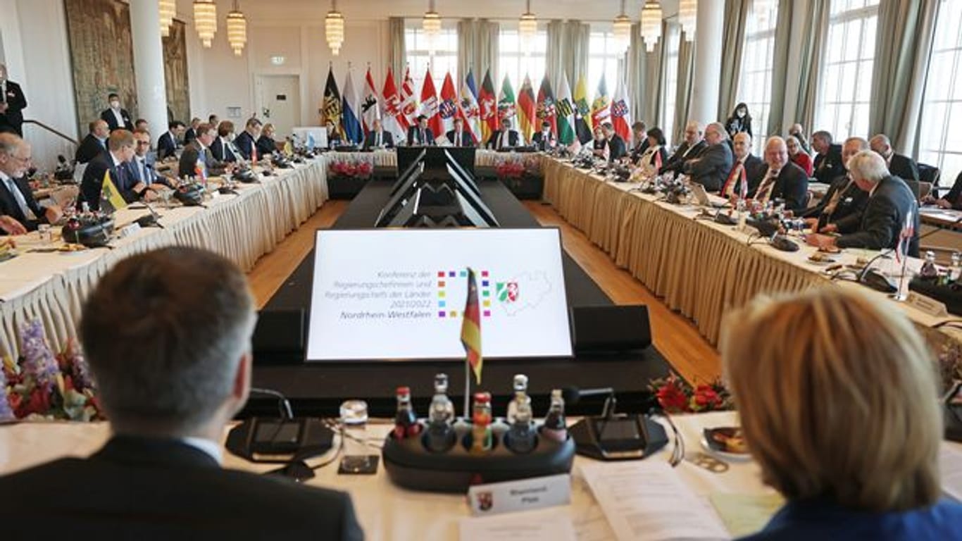 Die Ministerpräsidenten der Bundesländer sitzen am Konferenztisch zusammen.