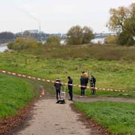 Ermittler in der Nähe des Leichenfundorts am Niehler Hafen: Ein 24-Jähriger ist bereits festgenommen worden.