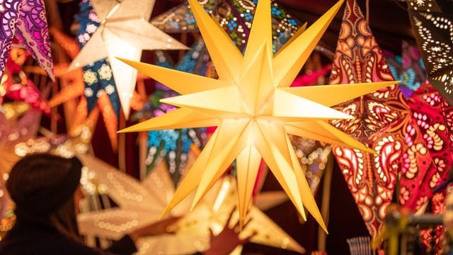 Weihnachtssterne hängen an einem Verkaufsstand