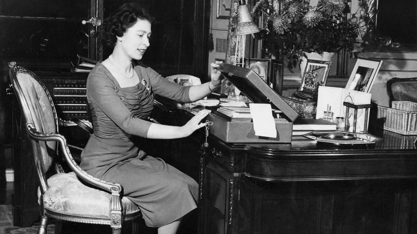 Queen Elizabeth II. 1959 an ihrem Schreibtisch beim Öffnen einer der "Red Boxes". Dieses Ritual befolgt sie noch heute.
