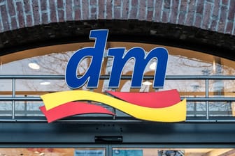 Das Logo der Drogeriekette dm hängt über dem Eingang zu einer Filiale (Symbolbild): In einem Spray des Unternehmens wurden jetzt Bakterien gefunden.