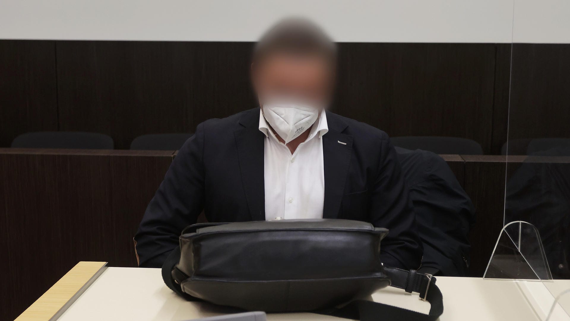 Der Angeklagte sitzt vor seiner Aktentasche im Gericht: Er wurde freigesprochen.
