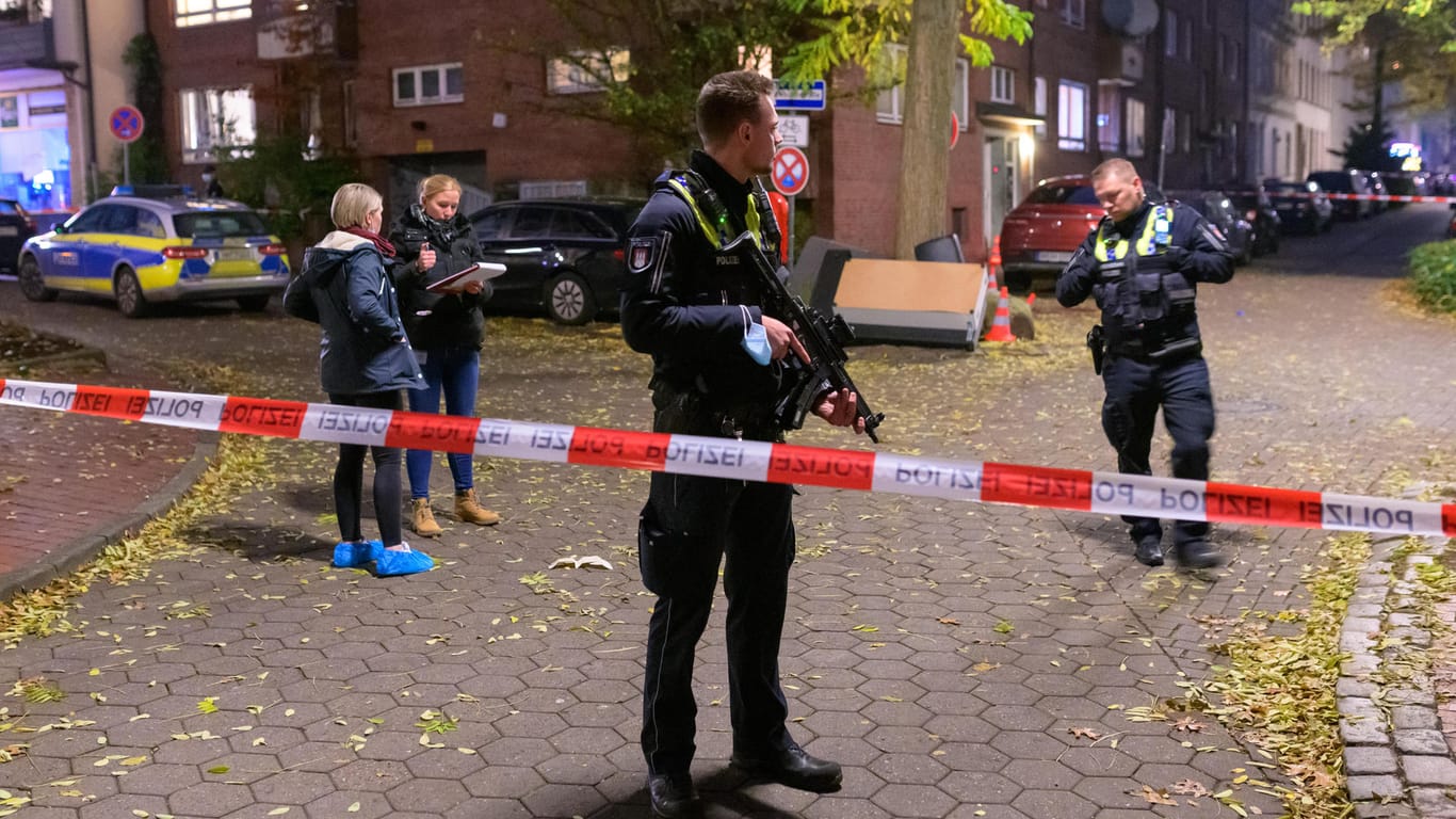 Ein Polizist mit einer Maschinenpistole sichert einen abgesperrten Tatort. In Hamburg-Harburg sind am Sonntagnachmittag Schüsse gemeldet worden.