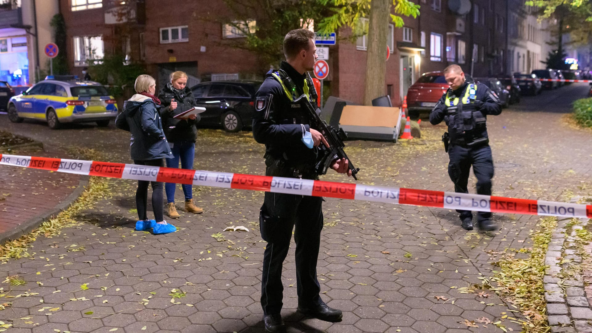 Ein Polizist mit einer Maschinenpistole sichert einen abgesperrten Tatort. In Hamburg-Harburg sind am Sonntagnachmittag Schüsse gemeldet worden. Ein Polizist mit einer Maschinenpistole sichert einen abgesperrten Tatort. In Hamburg-Harburg sind am Sonntagnachmittag Schüsse gemeldet worden.