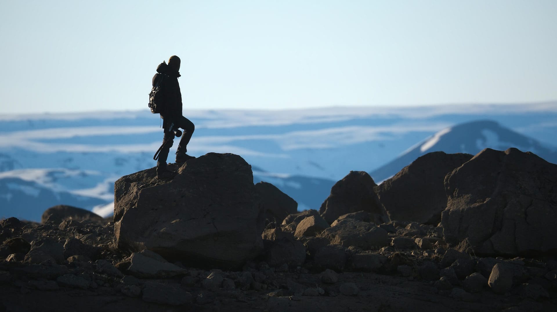 Ein Mann steht an einer Klippe. Lange Wandertouren sind gut für die mentale Entspannung und stärken den Körper.