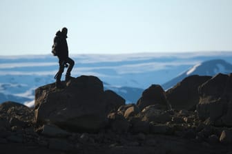 Ein Mann steht an einer Klippe. Lange Wandertouren sind gut für die mentale Entspannung und stärken den Körper.