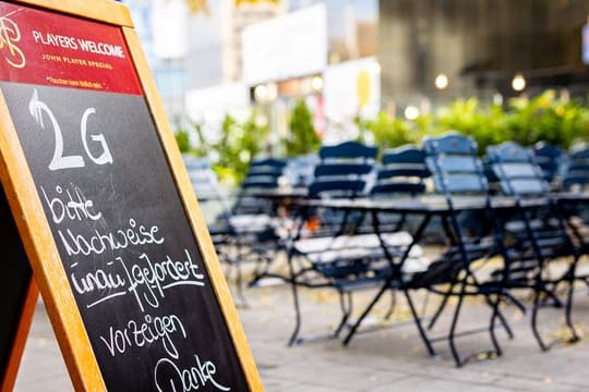 Ein Aufsteller auf der Terrasse eines Restaurants weist auf die 2G-Regel hin (Symbolbild): In Berlin soll 2G in vielen Bereichen erweitert werden.