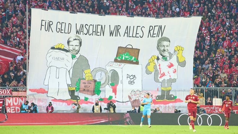 Fan-Banner der Münchner Kurve: Oliver Kahn (l.) und Herbert Hainer wurden für die Partnerschaft mit Katar kritisiert.