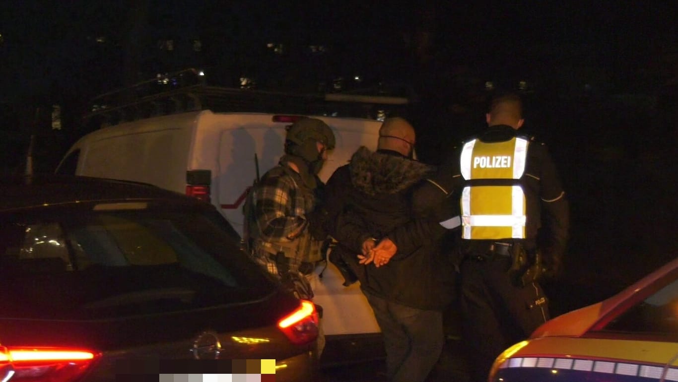 Festnahme in Chorweiler: Polizisten führen einen Tatverdächtigen ab.