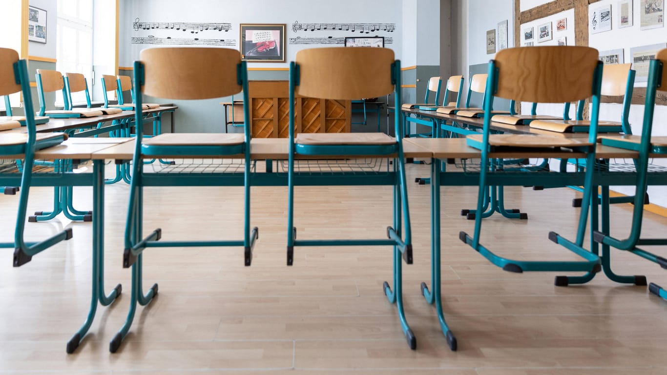Stühle sind in einem Klassenzimmer auf den Tischen aufgestelt (Symbolbild): Die halbe Schule war von dem Virusausbruch betroffen.