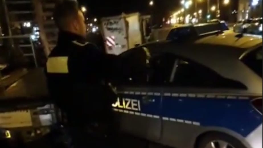 Ein Polizist steht neben einem verunfallten Einsatzwagen: Der Beamte, der am Steuer des Wagens saß, verstarb später im Krankenhaus.