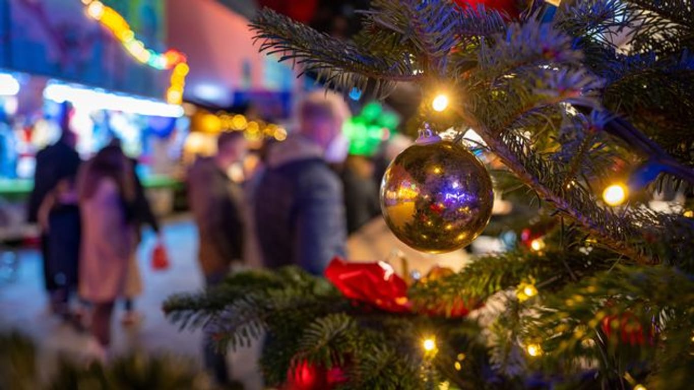 Ein festlich geschmückter Baum steht auf einem Weihnachtsmarkt (Symbolbild): Für viele sächsische Kommunen fällt der Adventszauber erneut ins Wasser.