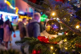 Ein festlich geschmückter Baum steht auf einem Weihnachtsmarkt (Symbolbild): Für viele sächsische Kommunen fällt der Adventszauber erneut ins Wasser.