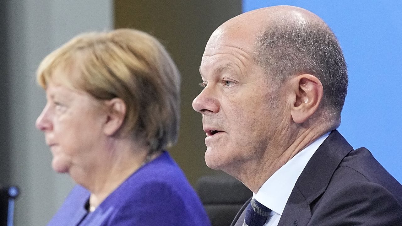 Die geschäftsführende Bundeskanzlerin Angela Merkel (CDU) und Olaf Scholz (SPD), geschäftsführender Bundesfinanzminister, nehmen im Anschluss an die Videokonferenz der Bundeskanzlerin mit den Ministerpräsidenten an einer Pressekonferenz im Bundeskanzleramt teil.
