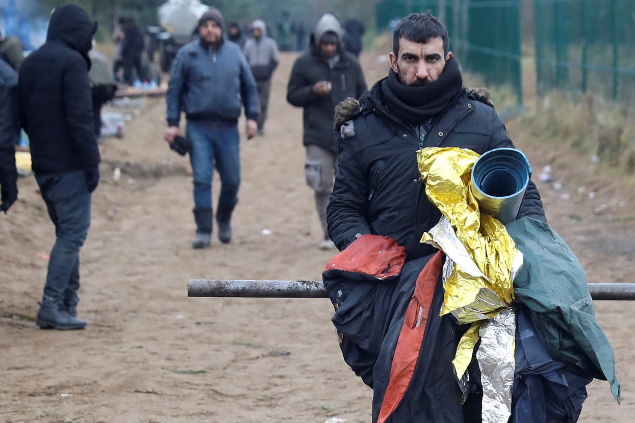 Migranten in einem Lager an der Grenze zu Belarus (Archivbild): Auf der anderen Seite des Zaunes sind Flüchtlinge in ein Logistikzentrum umgezogen.