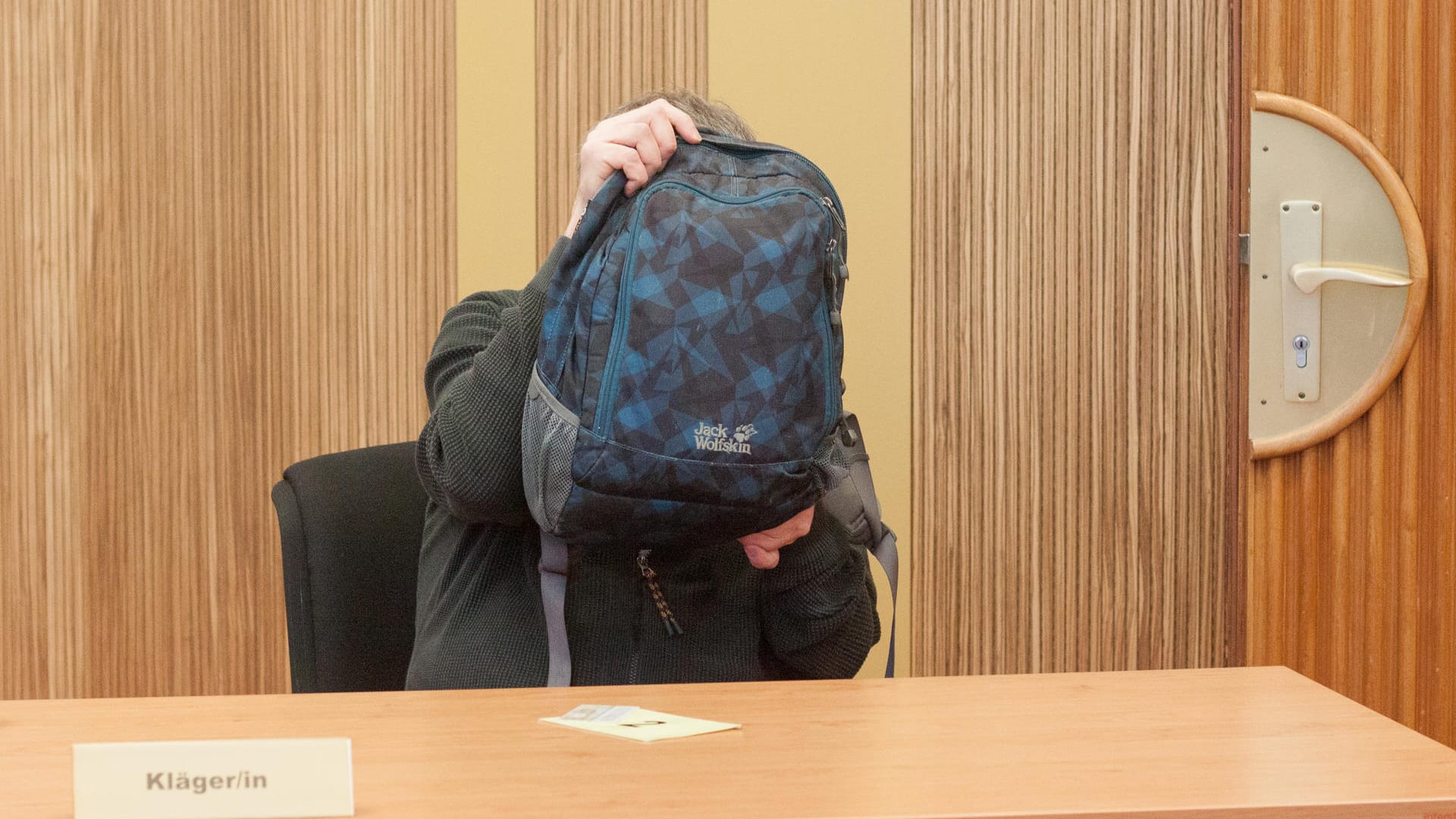 Der Mann wollte sich nicht zu erkennen geben: Für einen vermeintlich 102-Jährigen hielt er seinen Rucksack mit rund zehn Minuten erstaunlich lange als Sichtschutz hoch.