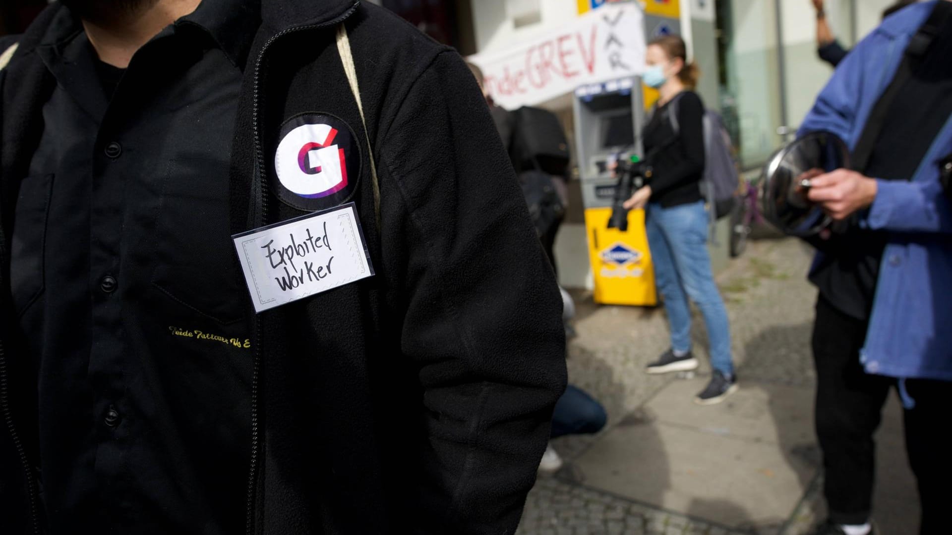 Ein Gorillas-Mitarbeiter im Streik, auf der Firmenweste ist ein Schild, auf dem "Exploited Worker", auf deutsch "ausgenutzter Mitarbeiter" steht (Symbolbild): Das Start-up wehrt sich gegen den Versuch der Mitarbeiter, einen Betriebsrat zu gründen. Ein Gorillas-Mitarbeiter im Streik, auf der Firmenweste ist ein Schild, auf dem "Exploited Worker", auf deutsch "ausgenutzter Mitarbeiter" steht (Symbolbild): Das Start-up wehrt sich gegen den Versuch der Mitarbeiter, einen Betriebsrat zu gründen.