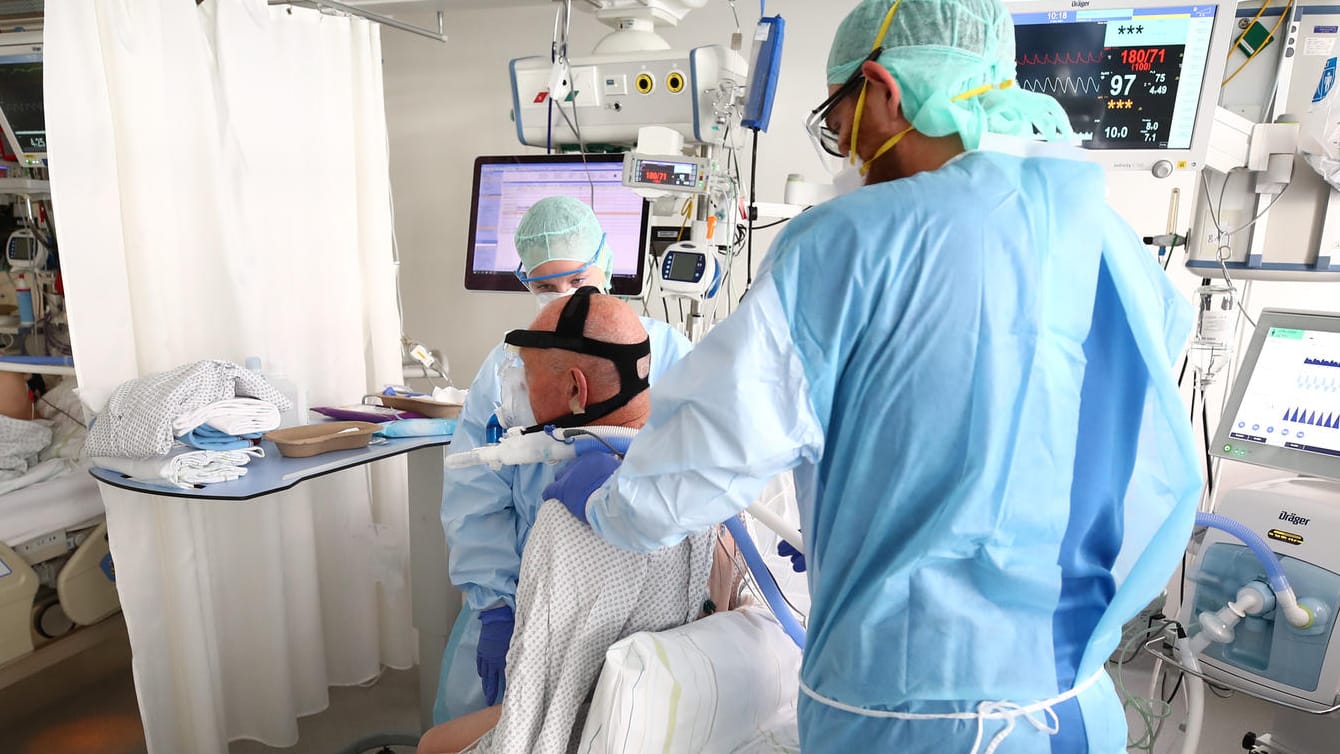 Ein Arzt untersucht einen Covid-Patienten auf einer Intensivstation (Symbolbild): Kliniken klagen über fehlende Intensivbetten.