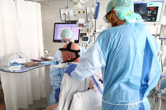 Ein Arzt untersucht einen Covid-Patienten auf einer Intensivstation (Symbolbild): Kliniken klagen über fehlende Intensivbetten.