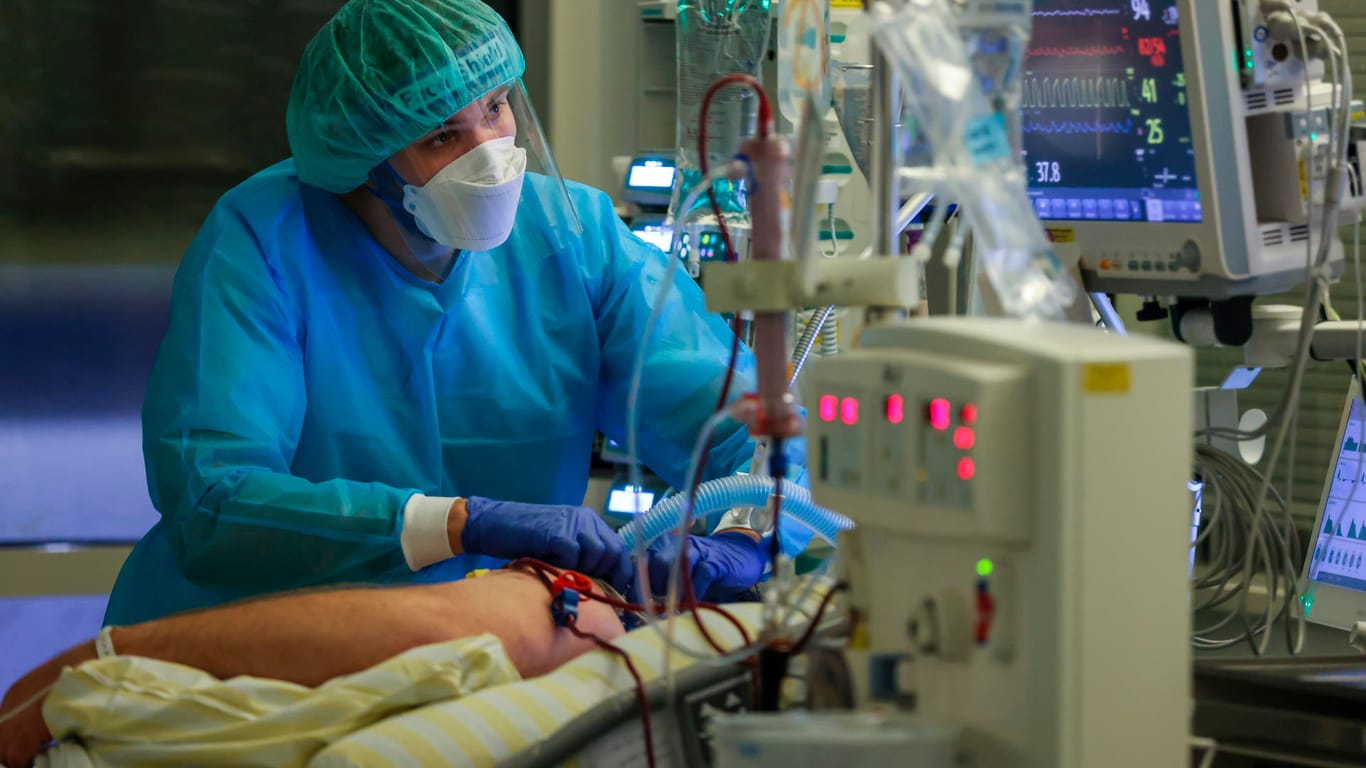 Ein Intensivpfleger versorgt einen Covid-19-Patienten auf der Intensivstation: Viele Pfleger arbeiten an der Belastungsgrenze oder darüber hinaus.