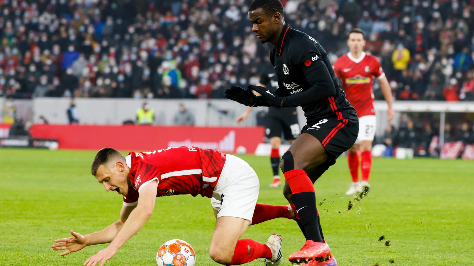 Freiburgs Maximilian Eggestein und Frankfurts Evan Ndicka kämpfen um den Ball.