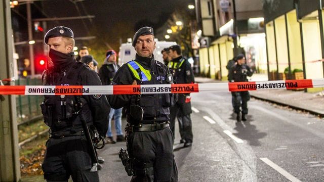 Polizisten stehen an einer abgesperrten Straße in der Innenstadt Polizisten stehen an einer abgesperrten Straße in der Innenstadt
