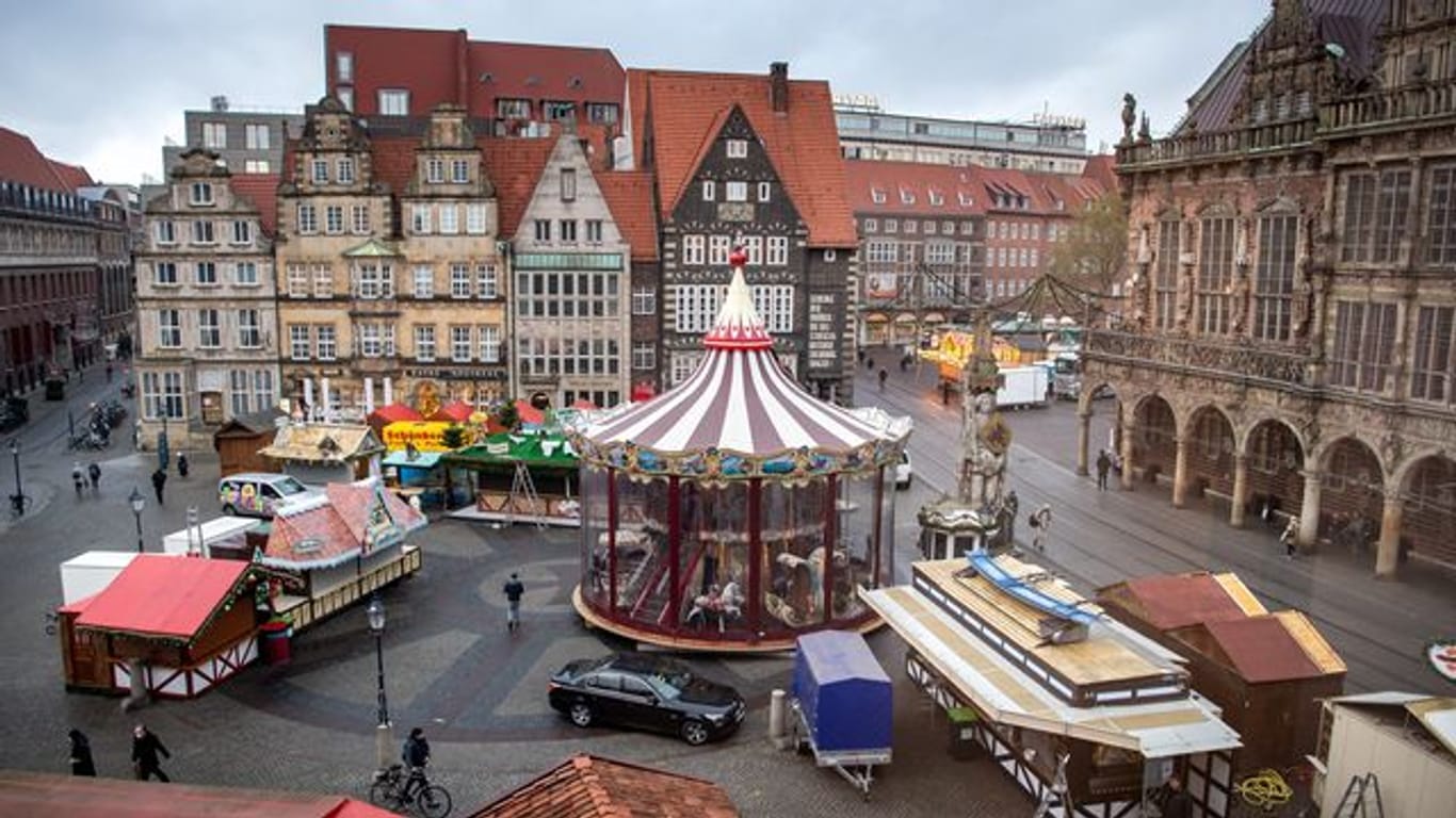 Aufbauarbeiten für den Weihnachtsmarkt am Bremer Marktplatz (Archivbild): Sollten die Infektionszahen weiter steigen, können 2G-Regeln in Kraft treten.