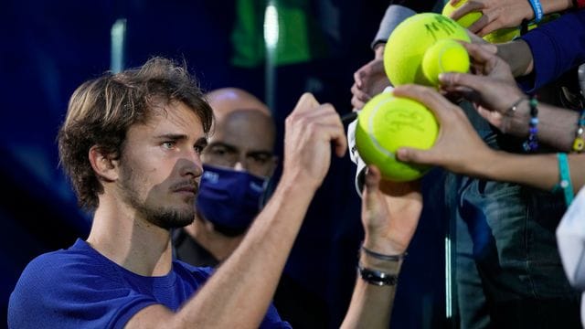 Alexander Zverev (l) gibt nach der ATP-Siegerehrung Autogramme.