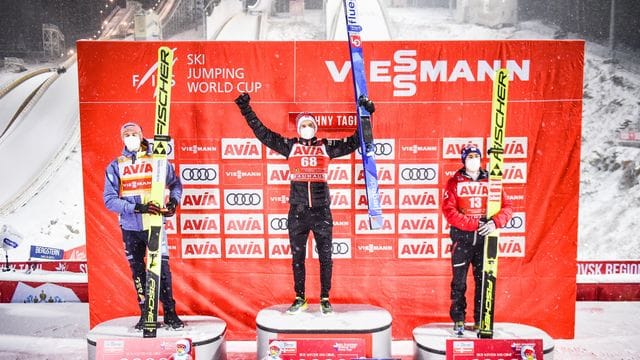 Halvor Egner Granerud (M) jubelt auf dem Podium nach seinem Sieg mit dem Zweiten, Karl Geiger (l) und dem Drittplatzierten Stefan Kraft. Halvor Egner Granerud (M) jubelt auf dem Podium nach seinem Sieg mit dem Zweiten, Karl Geiger (l) und dem Drittplatzierten Stefan Kraft.