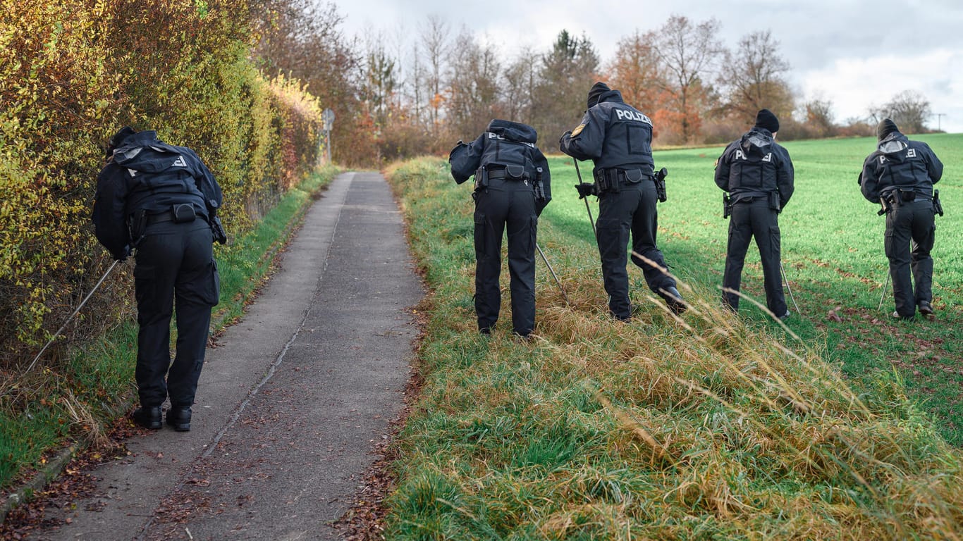 Polizisten durchsuchen das Gelände um den Tatort in Bayern: Hier wurde ein toter Radfahrer entdeckt.