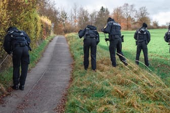Polizisten durchsuchen das Gelände um den Tatort in Bayern: Hier wurde ein toter Radfahrer entdeckt.