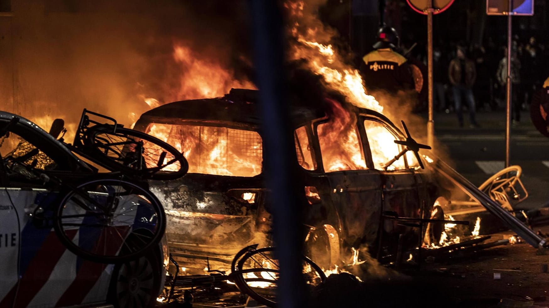 Ein Auto brennt in Rotterdam: Bei schweren Ausschreitungen hat es nach Schüssen der Polizei Verletzte gegeben.