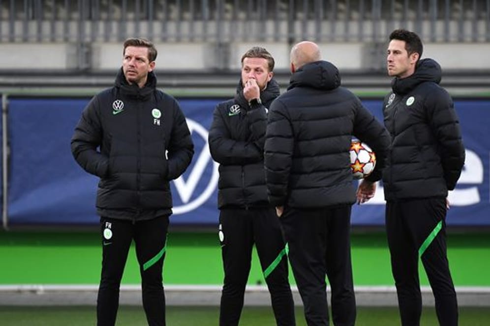 Vor dem Abflug nach Sevilla war Corona wieder ein Thema: Wolfsburgs Trainer Florian Kohfeldt (l) steht mit seinem Team zusammen.