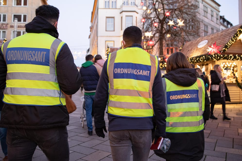 Ordnungsamtsmitarbeiter kontrollieren auf dem Weihnachtsmarkt in Bielefeld die Einhaltung von 2G-Regeln: Die USA warnen wegen der Corona-Situation vor Reisen nach Deutschland.