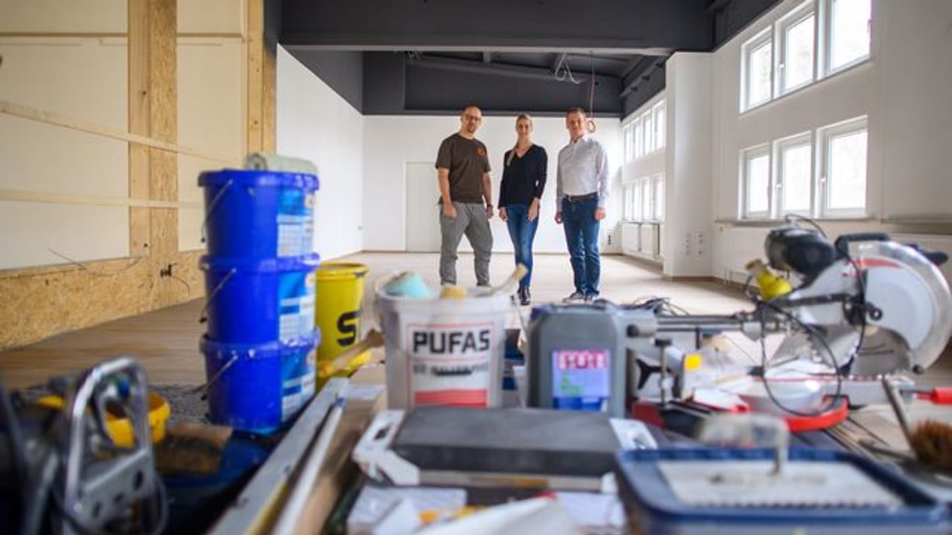 Sebastian Gauck (l-r), Sandra Gauck und Sebastian Herden stehen in der zukünftigen Kreativwerkstatt, die derzeit aufgebaut wird.