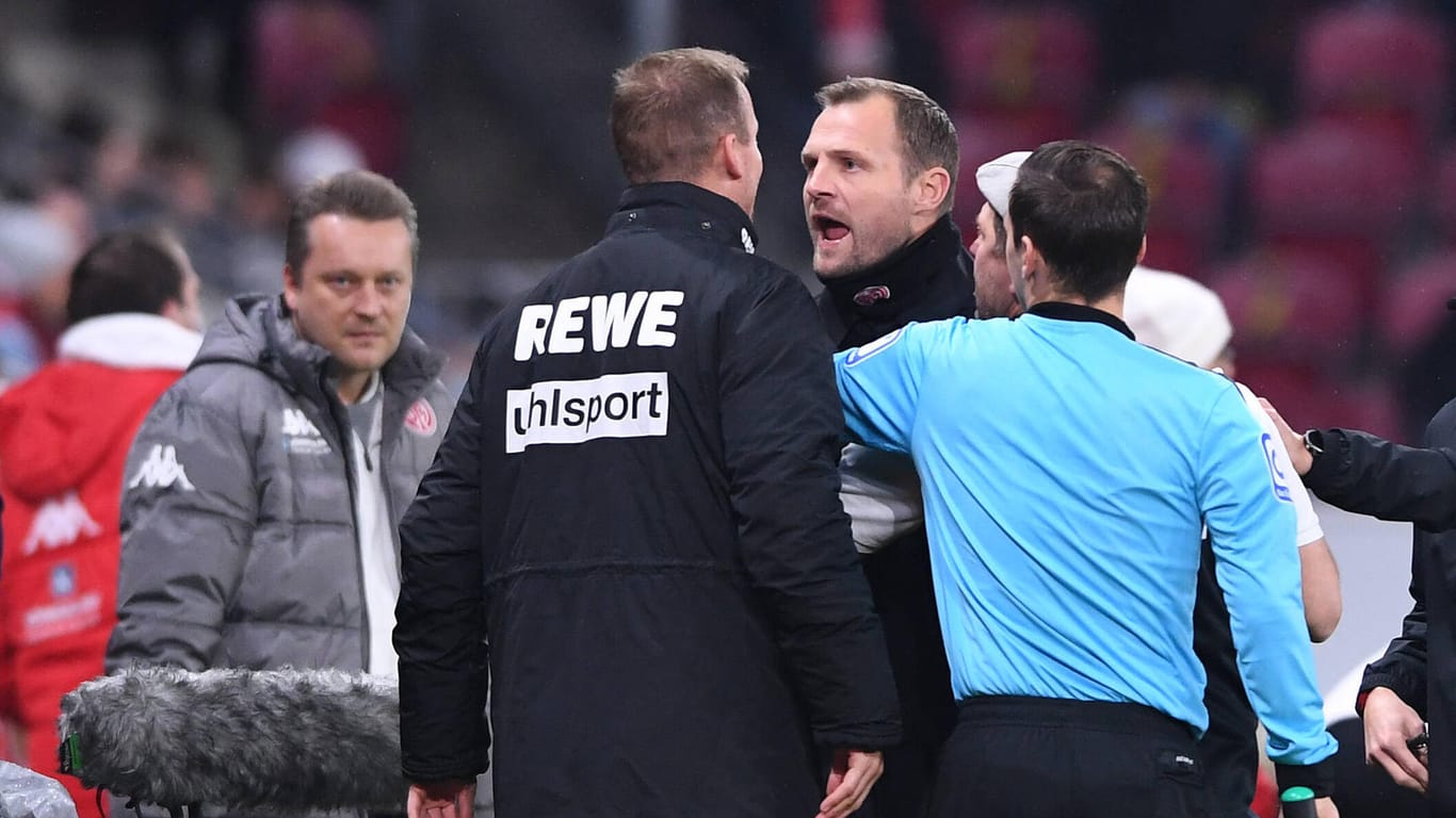 Im hitzigen Wortgefecht: Mainz-Trainer Bo Svennson und FC-Co-Trainer Kevin McKenna. Dazwischen Steffen Baumgart und der Schiedsrichter.
