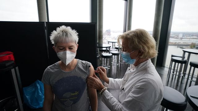 Eine Frau bekommt eine Spritze: Inga Reuters (links) erhält in der Skyline Bar "20up" ihre Booster-Impfung.