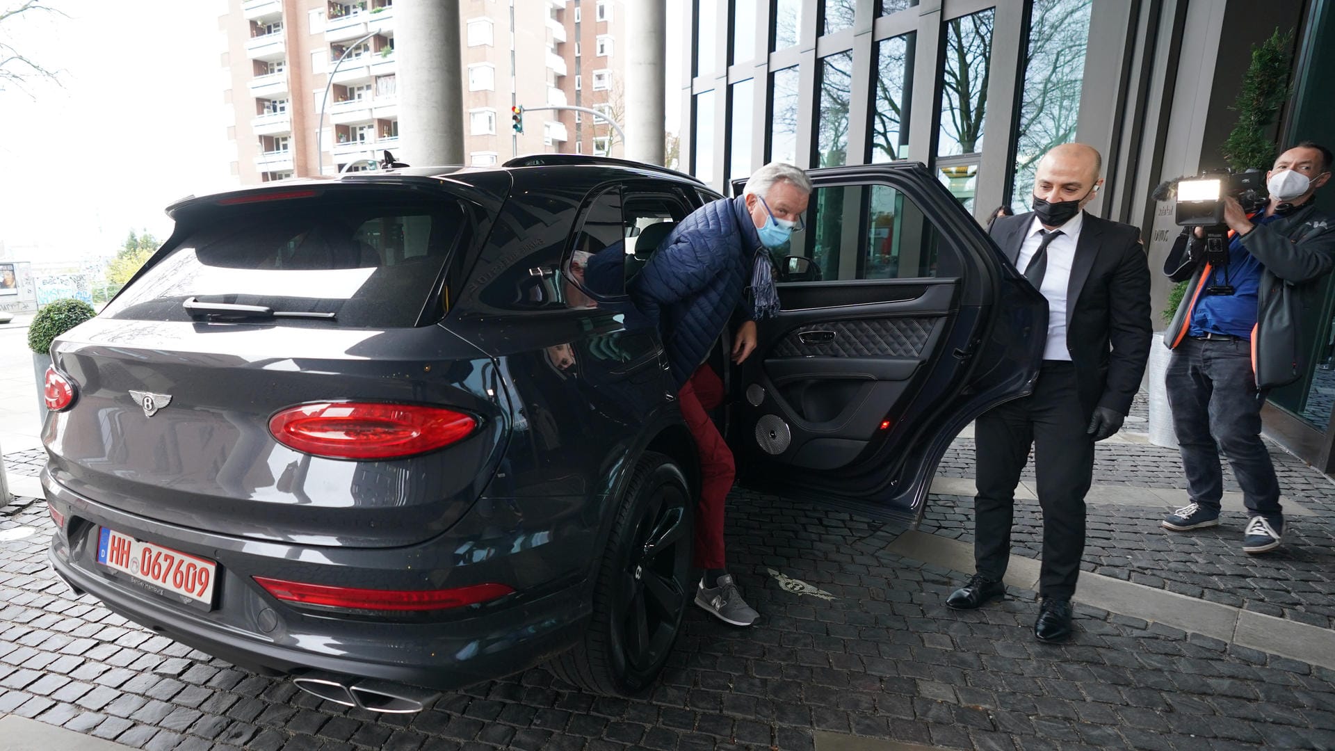 Ein Chauffeur öffnet einem Mann die Tür: Bei der Impfaktion in Hamburg konnten sich Patienten per Luxus-SUV zum Termin fahren lassen. Ein Chauffeur öffnet einem Mann die Tür: Bei der Impfaktion in Hamburg konnten sich Patienten per Luxus-SUV zum Termin fahren lassen.