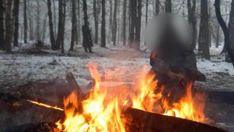 Ein Bewohner des Camps wärmt sich am Lagerfeuer: Es ist eines der wenigen Bilder, die Anas H. machen konnte. Normalerweise verwahrten belarussische Soldaten die Handys.