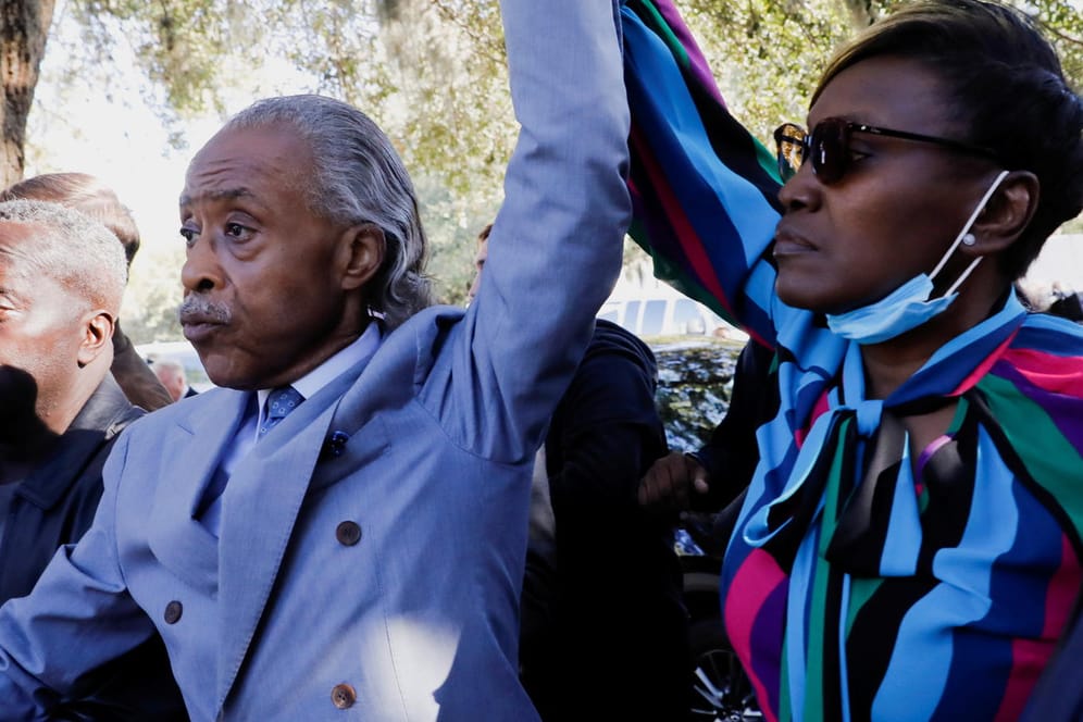 Der Bürgerrechtler Al Sharpton und die Mutter von Ahmaud Arbery, Wanda Cooper-Jones, recken nach der Urteilsverkündung ihre Arme in die Höhe.