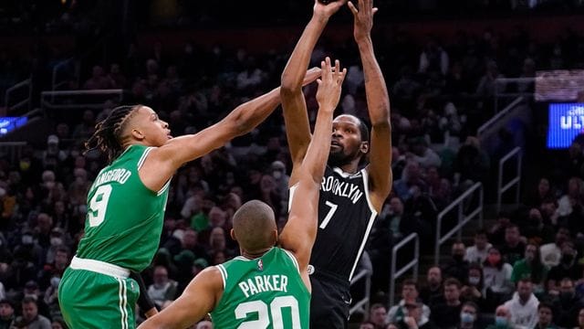 Brooklyn Nets-Forward Kevin Durant (r) wirft, während er von Boston Celtics-Guard Romeo Langford (l) und Forward Jabari Parker verteidigt wird. Brooklyn Nets-Forward Kevin Durant (r) wirft, während er von Boston Celtics-Guard Romeo Langford (l) und Forward Jabari Parker verteidigt wird.