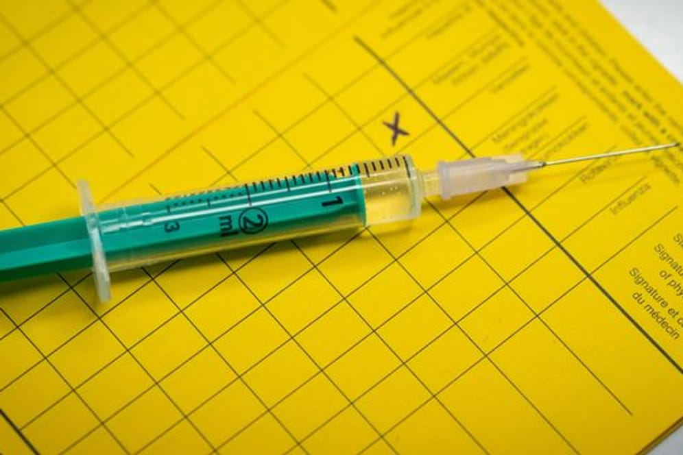 Eine Spritze liegt auf einem Impfpass (Symbolbild): Die Situation an Schulen soll mit der Impfung entschärft werden.