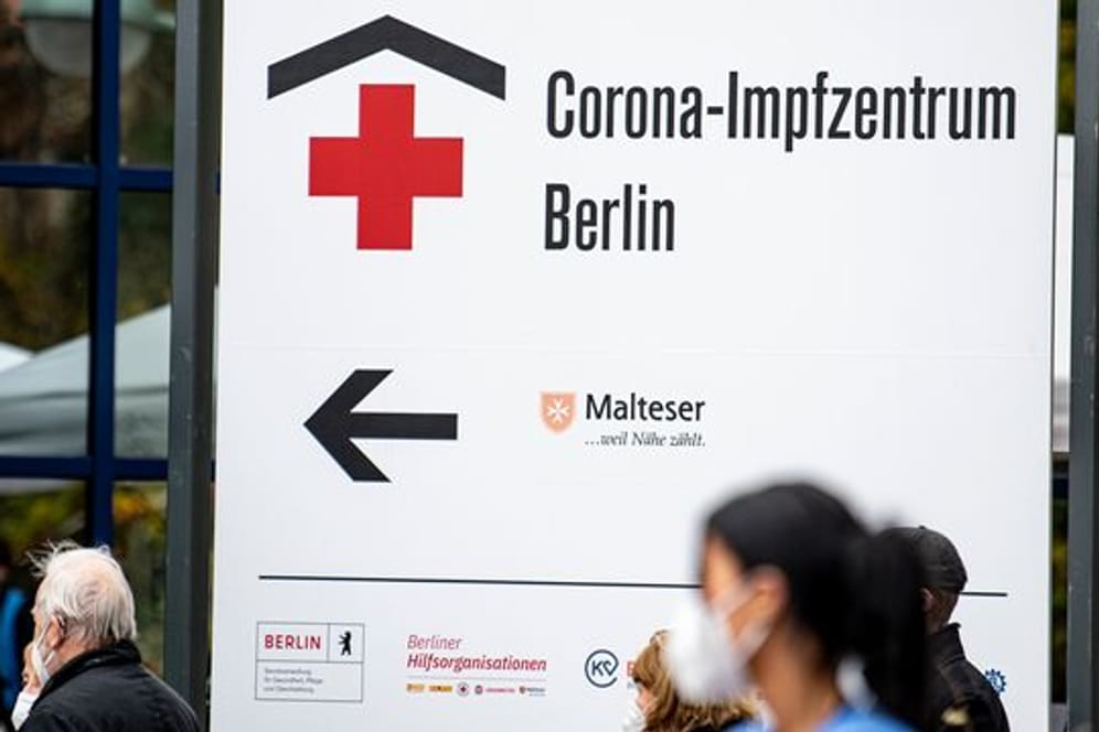 Menschen stehen vor dem Eingangsschild des Corona-Impfzentrums Messe Berlin. (Archivbild) Das Impfzentrum bleibt bis Februar geöffnet.