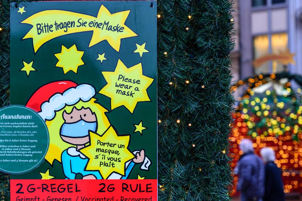 Hinweisschild auf dem Weihnachtsmarkt am Kölner Dom: Für Weihnachtsmärkte in Köln gelten ab heute 2G-Regel und Maskenpflicht.