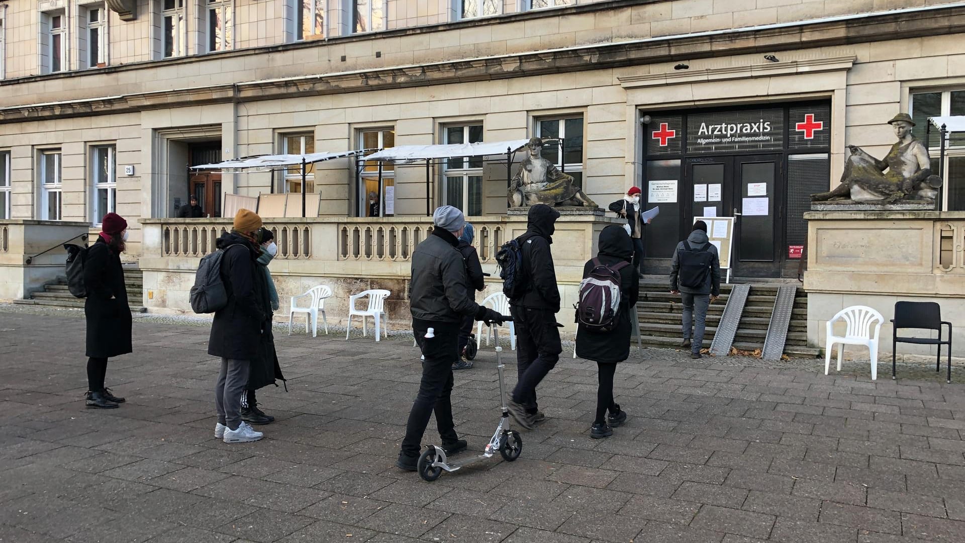 Vor einer Arztpraxis in Friedrichshain ist eine lange Schlange. Hier wird "im Vorbeigehen" aus einem Fenster der Praxis geboostert – ohne Termin.